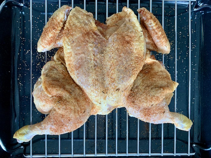 kuře naplacato na roštu před pečením